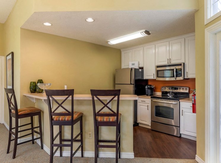 Clubhouse interior with fully equipped kitchen, white cabinets, and hardwood style flooring